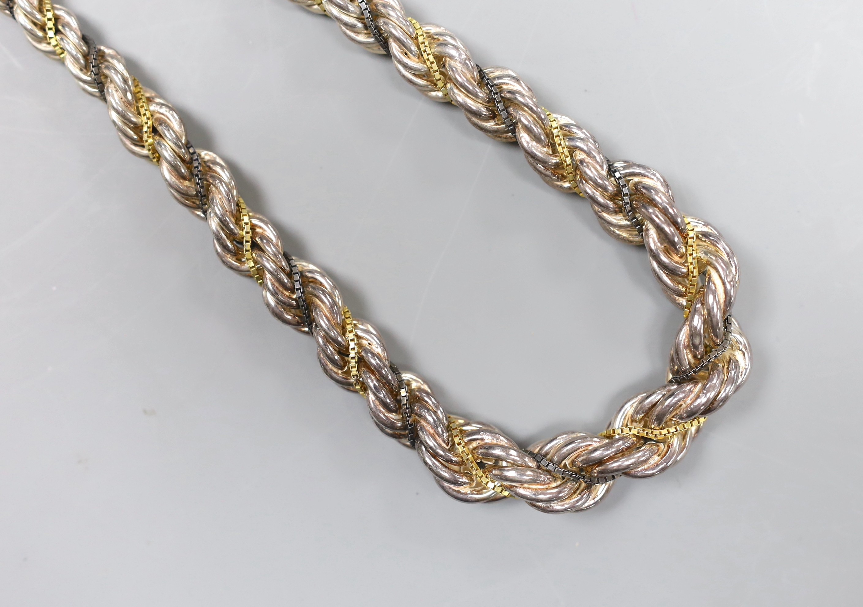 A Continental white metal, gilt and oxidised metal three strand ropetwist chain necklace, 50cm